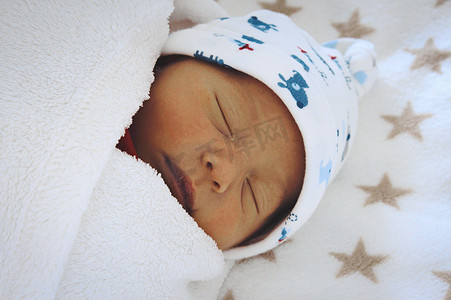 襁褓摄影照片_刚出生的婴儿裹着襁褓睡觉