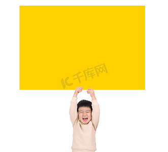 海报可爱黄色摄影照片_拿着空的黄色板的愉快的小男孩