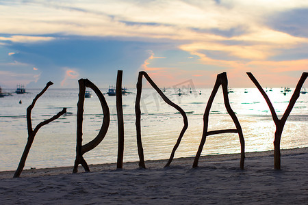 热带岛屿上完美的白色沙滩，木制字母剪影制作了星期五词