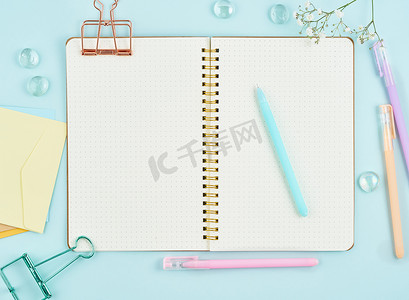 蓝色办公室桌面上的项目符号日记中的空白记事本页。