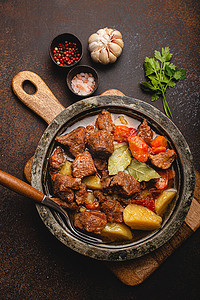 胡萝卜土豆摄影照片_乡村金属锅顶视图中的肉牛肉炖菜和肉汁