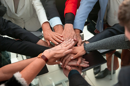 合作的双手摄影照片_在视图下，业务团队合作将人们的双手堆叠在一起