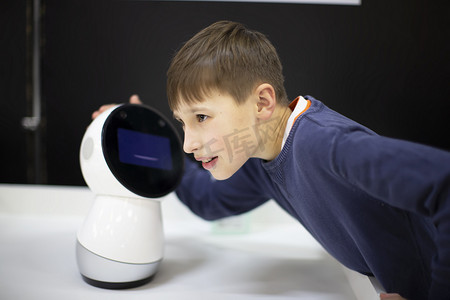 安卓机器人摄影照片_男孩在展览上说话，玩安卓机器人