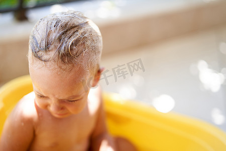 头发湿漉漉的小女孩在一碗水里哭泣