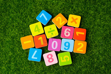 学习数学摄影照片_草地背景上的数学数字五颜六色，教育学习数学学习教学理念。