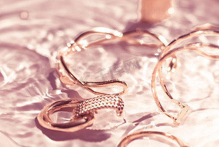玫瑰金手镯、耳环、戒指、粉色水背景的珠宝、奢华魅力和珠宝品牌广告的假日美容设计