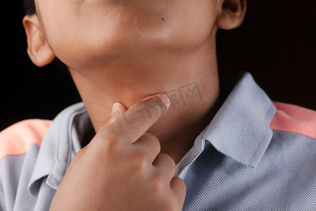 喉咙痛摄影照片_十几岁的男孩喉咙痛特写