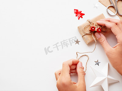 女人用牛皮纸包装圣诞节和新年 DIY 礼物。