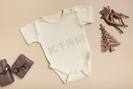 黄色婴儿紧身衣模型，用于米色背景上的徽标、文字或设计，具有冬季装饰顶视图