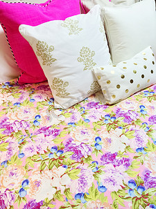 枕套摄影照片_床上配有色彩缤纷的花卉设计床上用品