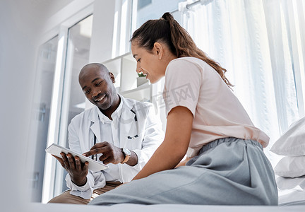 医生预约或医疗保健专业人员咨询患者并在平板电脑上显示她的在线医疗结果。