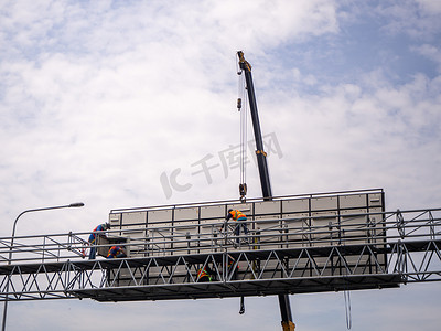 建筑工地起重机正在吊起广告用的 LED 招牌