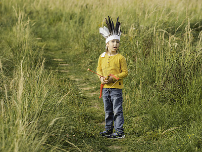 美国制作手工摄影照片_小男孩正在球场上玩美洲印第安人。