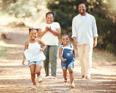 孩子加油摄影照片_夏天，快乐的黑人家庭和孩子们在自然公园里跑步，爸爸妈妈为他们年轻的非洲孩子加油。