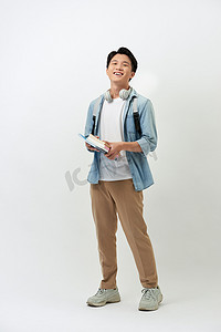 快乐的年轻亚洲学生，带着书本、耳机、背包，随意地站在白色背景上。
