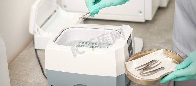 医疗清洁摄影照片_用医疗器械清洁系统对镊子进行手消毒。