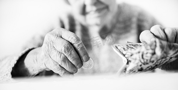 详细的特写照片显示，无法辨认的老年妇女在支付账单后，双手数着钱包里养老金中剩余的硬币。