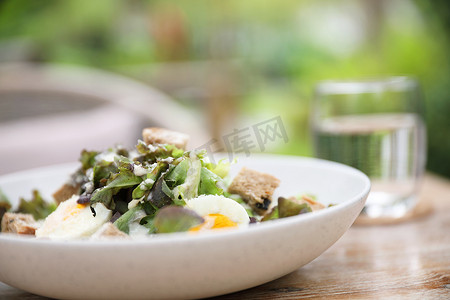 凯撒沙拉摄影照片_木质背景上的凯撒沙拉开胃菜
