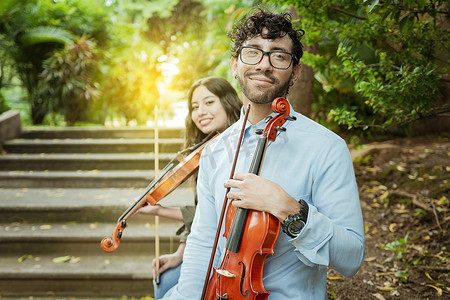 坐在外面的两位年轻中提琴手的肖像。