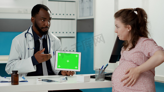 产科医生在平板电脑上使用水平绿屏