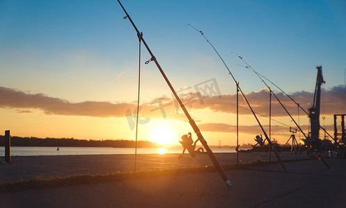 钓鱼竿，背景码头河岸上的旋转卷轴。