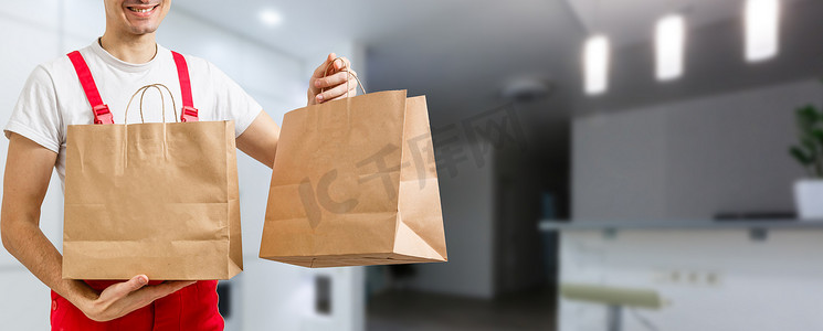 送货、邮件和人的概念-快乐的人用一次性纸袋把食物送到顾客家