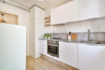 白色的现代厨房摄影照片_带白色家具的现代厨房内部