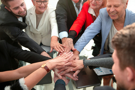 在视图下，业务团队合作将人们的双手堆叠在一起