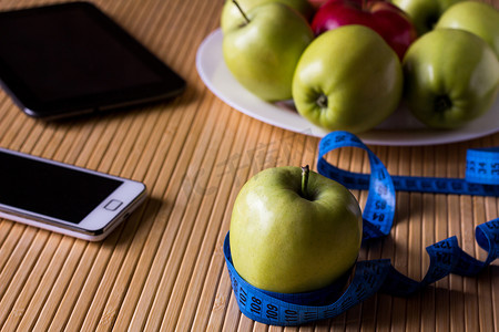 苹果放在浅竹桌上的盘子上。