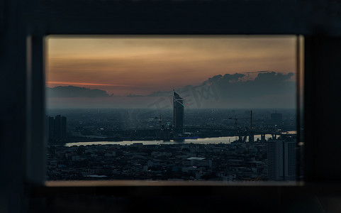 华丽的日出或日落全景，曼谷市的鸟瞰图，俯瞰摩天大楼和横跨湄南河的桥梁，闪烁着明亮的灯光。