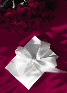 惊喜礼盒摄影照片_豪华假日丝绸礼盒和葡萄酒背景玫瑰花束、浪漫惊喜和鲜花作为生日或情人节礼物