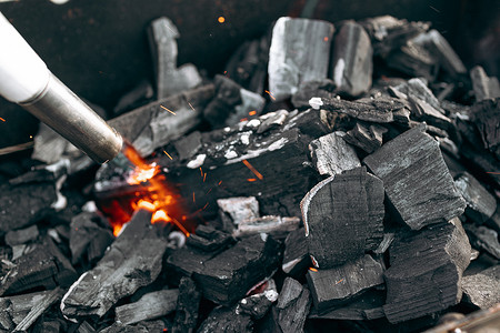 点燃火焰摄影照片_燃气燃烧器在烤架上点燃煤