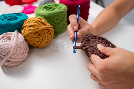 一位女士正在编织一篮子棉纱的特写镜头。