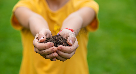 孩子手里拿着泥土。