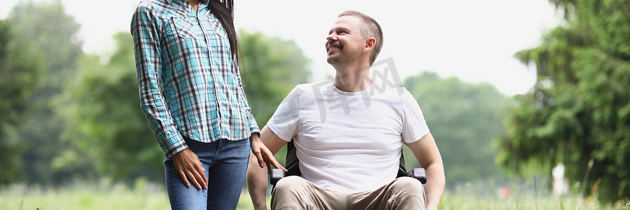 男子坐在轮椅上，女访客在疗养院与朋友共度时光