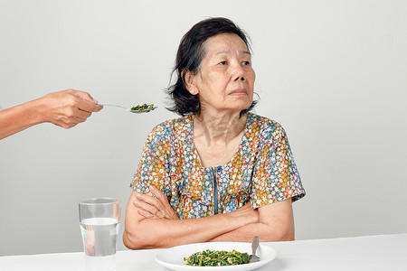 厌倦食物的亚洲老妇人