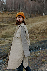 秋摄影照片_戴着橙色帽子的女人自然秋河景观