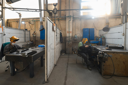 焊接摄影照片_在工厂工作的金属工业工人，在冠状病毒或 covid19 大流行期间戴着防护面罩。
