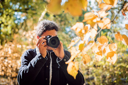 拍摄秋天公园的男摄影师