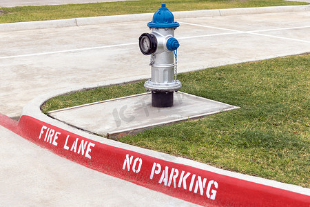 人行道上的灰色和蓝色消防栓，红色消防车道在街道的人行道上没有停车标记。