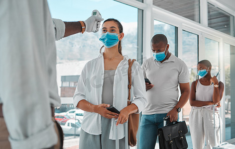 筛查摄影照片_Covid 安全旅行，带温度计测试和筛查的医生或医疗保健人员在机场对人员进行协议检查。
