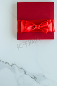 红色节日礼物盒摄影照片_大理石上的豪华红色节日礼物
