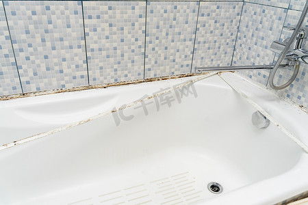 浴室淋浴间的脏瓷砖上覆盖着霉菌和霉菌的密封剂