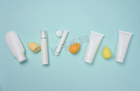 包装广告设计摄影照片_蓝色背景中用于奶油、凝胶和其他化妆品和海绵的白色塑料管