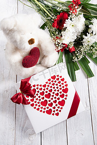 情人节礼物、带心的泰迪熊、一盒果仁糖和一束花