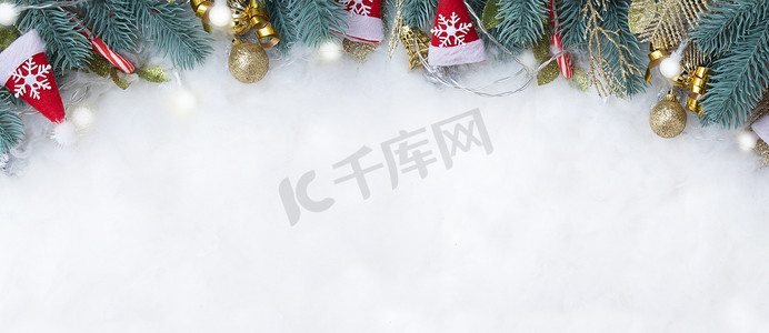 金色雪花背景图摄影照片_带有冷杉树枝和圣诞装饰的横幅平铺在雪地背景上，并有复制空间
