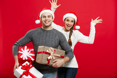 圣诞节概念 — 年轻漂亮的夫妇拿着很多礼物，喜欢在圣诞节购物和庆祝