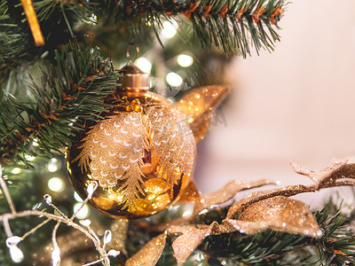 金色的装饰摄影照片_圣诞树上有金色的装饰。