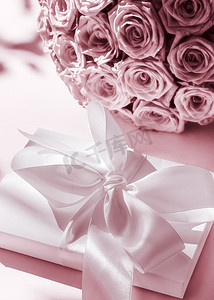 豪华假日丝绸礼盒和玫瑰花束，粉红背景、浪漫惊喜和鲜花作为生日或情人节礼物