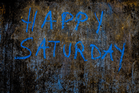 快乐星期六用蓝色粉笔在粗糙的墙上写下，特写水平镜头。